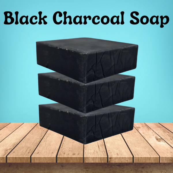 "Black Charcoal soap" is on the title all in black. there are 3 back charcoal plain soaps stacked on top of each other with a light blue background all sitting on a light wood deck  