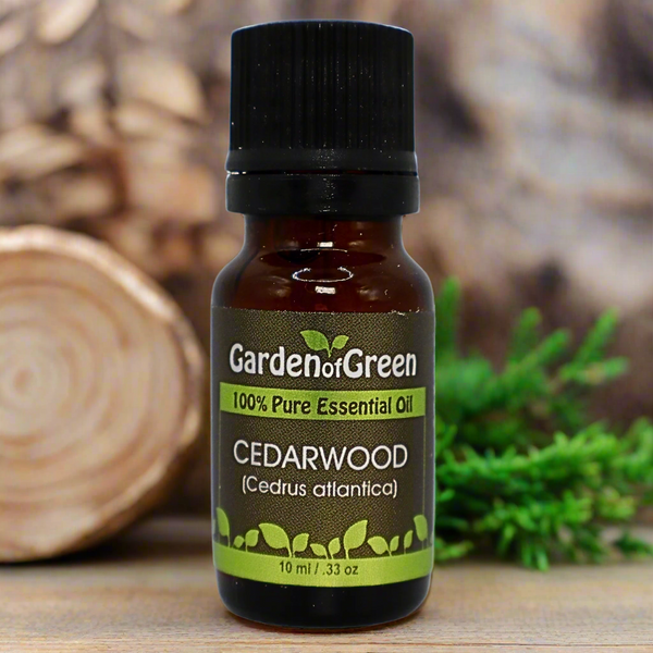 cedarwood essential oil with a log on the left. the oil is sitting on a wood table