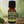 Ginger Garden of green essential oil Ginger essential oil sitting on a white kitchen counter with a ginger root sitting on the left side front of the bottle