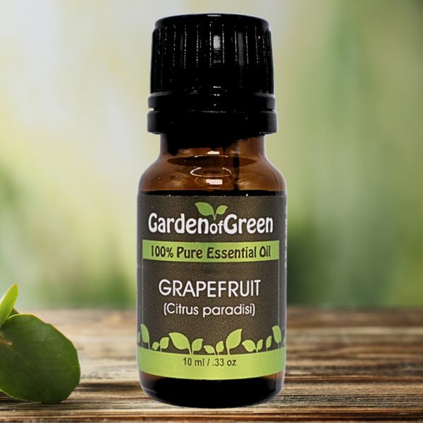 Grapefruit Garden of green essential oil Grapefruit essential oil sitting on the white kitchen table next to a sink with cut grapefruit in front of the essential bottle