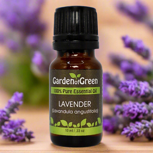 Lavender Garden of green essential oil front view sitting on a wood table with a leaf on the lower left hand side. green background with sun shining through the top left.