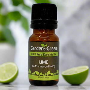 Lime Garden of green essential oil front view sitting on a wood table with a leaf on the lower left hand side. green background with sun shining through the top left.