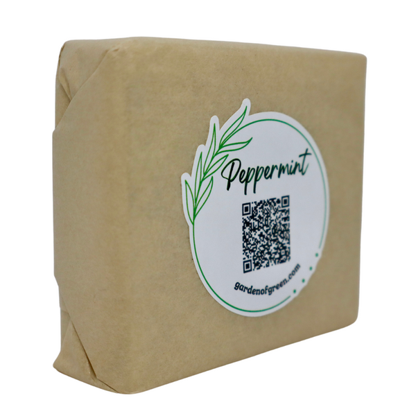 Garden of Green's peppermint soap side view wrapped in tan tissue with a cute sticker stating peppermint and a QR code. all on a white background