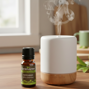 Petitgrain essential oil front view sitting on a wood table with a leaf on the lower left hand side. sitting in the kitchen sitting next to a diffuser 