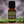 Rosemary essential oil family-crafted aromatherapy oil, front view sitting on a wood table with a sprig of rosemary on both sides 
