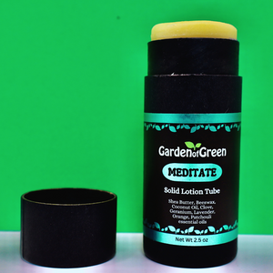 Garden of Green's Solid Lotion Tube front view sitting on a white table with a green background