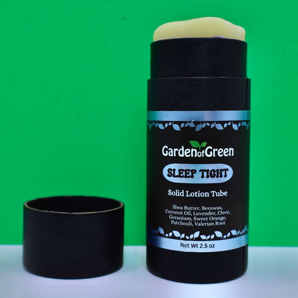 Garden of Green's Sleep Tight solid lotion tube front view sitting on a white table with a green background