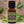 Spikenard essential oil front view sitting on a wood table with a leaf in the background. 