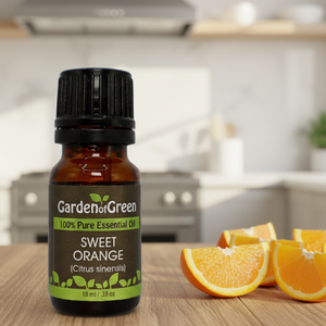 Sweet Orange essential oil front view sitting on a wood table in the kitchen sliced oranges on the right side of it.