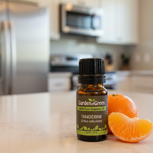 Tangerine Garden of green essential oil front view of our tangerine essential oil up close with a kitchen in the background and a tangerine slice and a whole one sitting next to it on the right