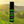 Garden of Green's Tea Tree essential oil roller front view with a yellow and green vineyard in the background 