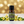 Ylang Ylang essential oil front view sitting with flowers in the background